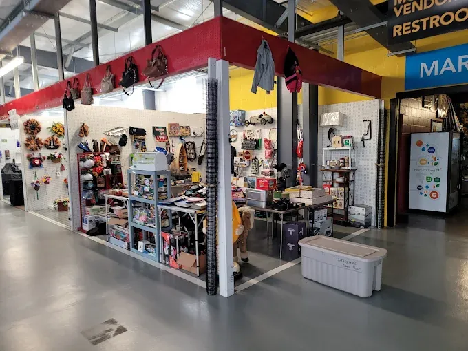 a vibrant caesar creek flea market stall with various items for sale, including bags, crafts, and vintage goods. the space is well-organized and inviting.