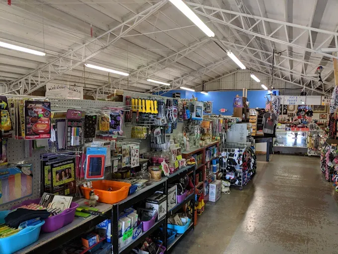 a jamie's flea market interior with high ceilings displays an assortment of tools, crafts, and household items on shelves