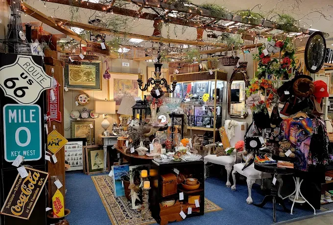 a vibrant antique store corner filled with vintage decor, route 66 sign, chandeliers, colorful flowers, and various trinkets at springfield antique center