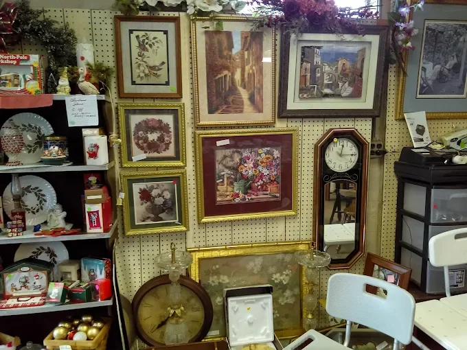 at carducci's 2nd hand shop display with framed art and mirrors on a pegboard wall