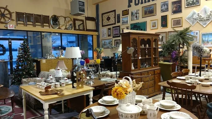 Furniture display at the estate marketplace featuring dining sets, a hutch, and wall art.