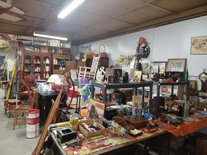 indoor stall at hfm emporium featuring vintage collectibles, model trains, and antique books on display tables.