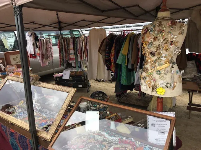 outdoor market stall displaying vintage clothing and accessories at burton antiques show